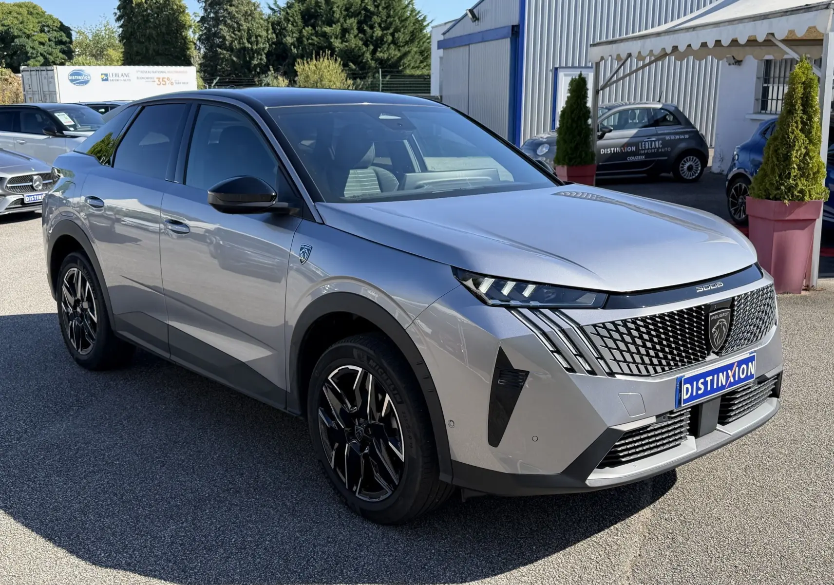 Peugeot 3008 gris clair en 3/4 avant droit, avec calandre noire distinctive et jantes noires stylisées.