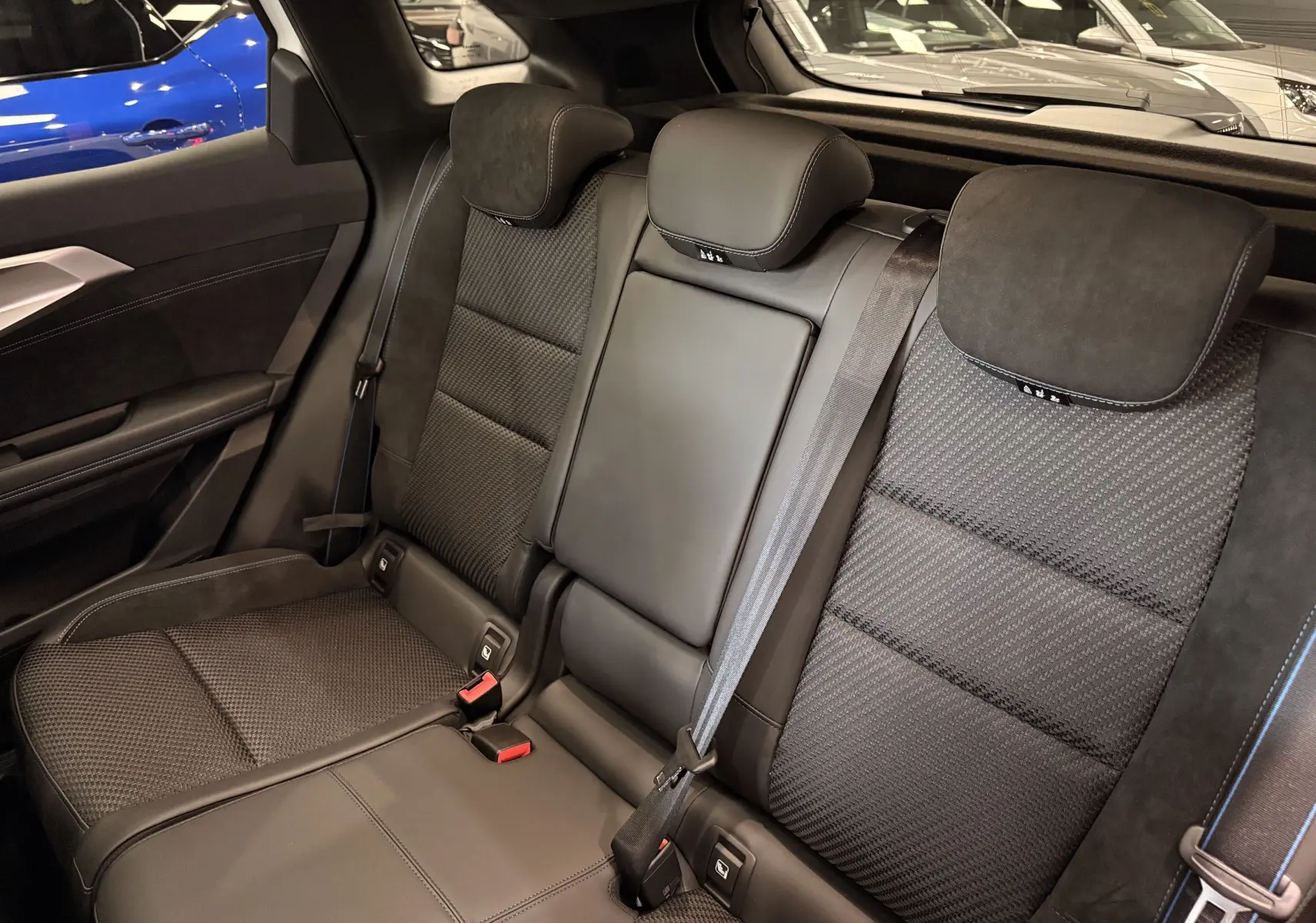 Vue intérieure des sièges arrière en tissu et cuir noir du Renault Austral full hybrid 2026, avec appuie-têtes et ceintures visibles.