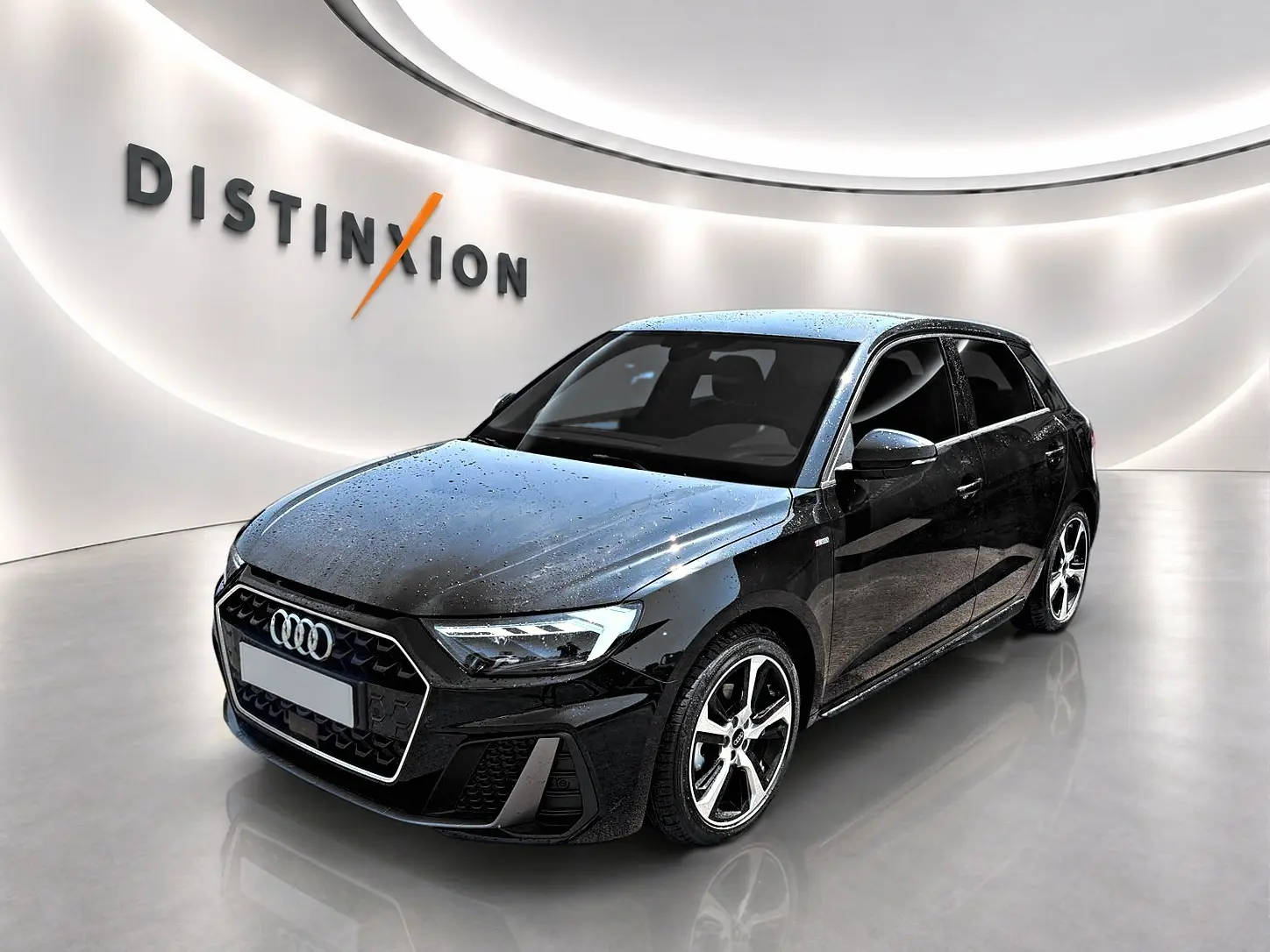 Audi A1 Sportback noir vue 3/4 avant droit avec jantes alliage et phares LED dans un showroom lumineux.