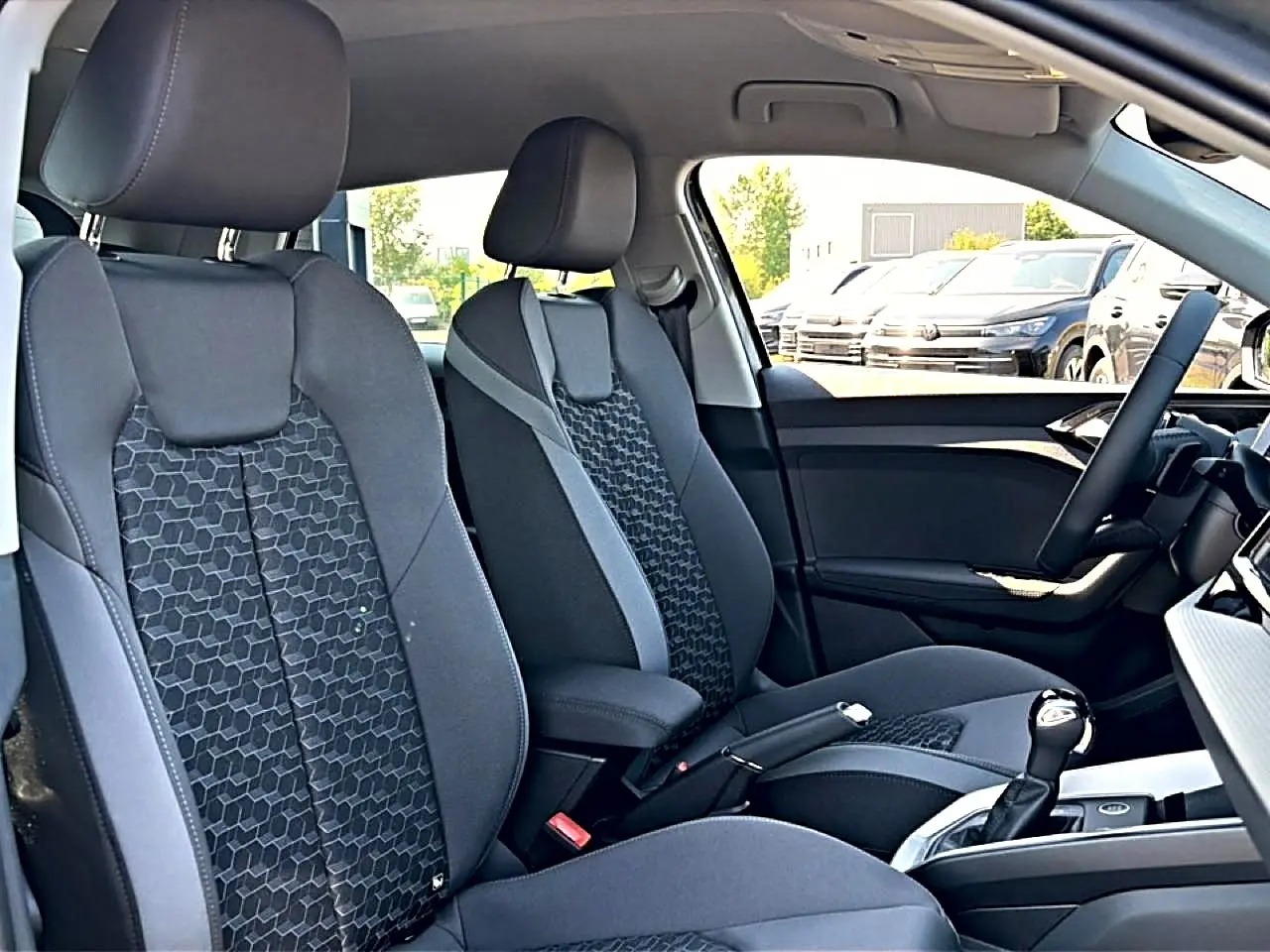 Vue intérieure côté droit de l’Audi A1 Sportback 30 TFSI 116 S line 2026, sièges sport noirs avec motif hexagonal.