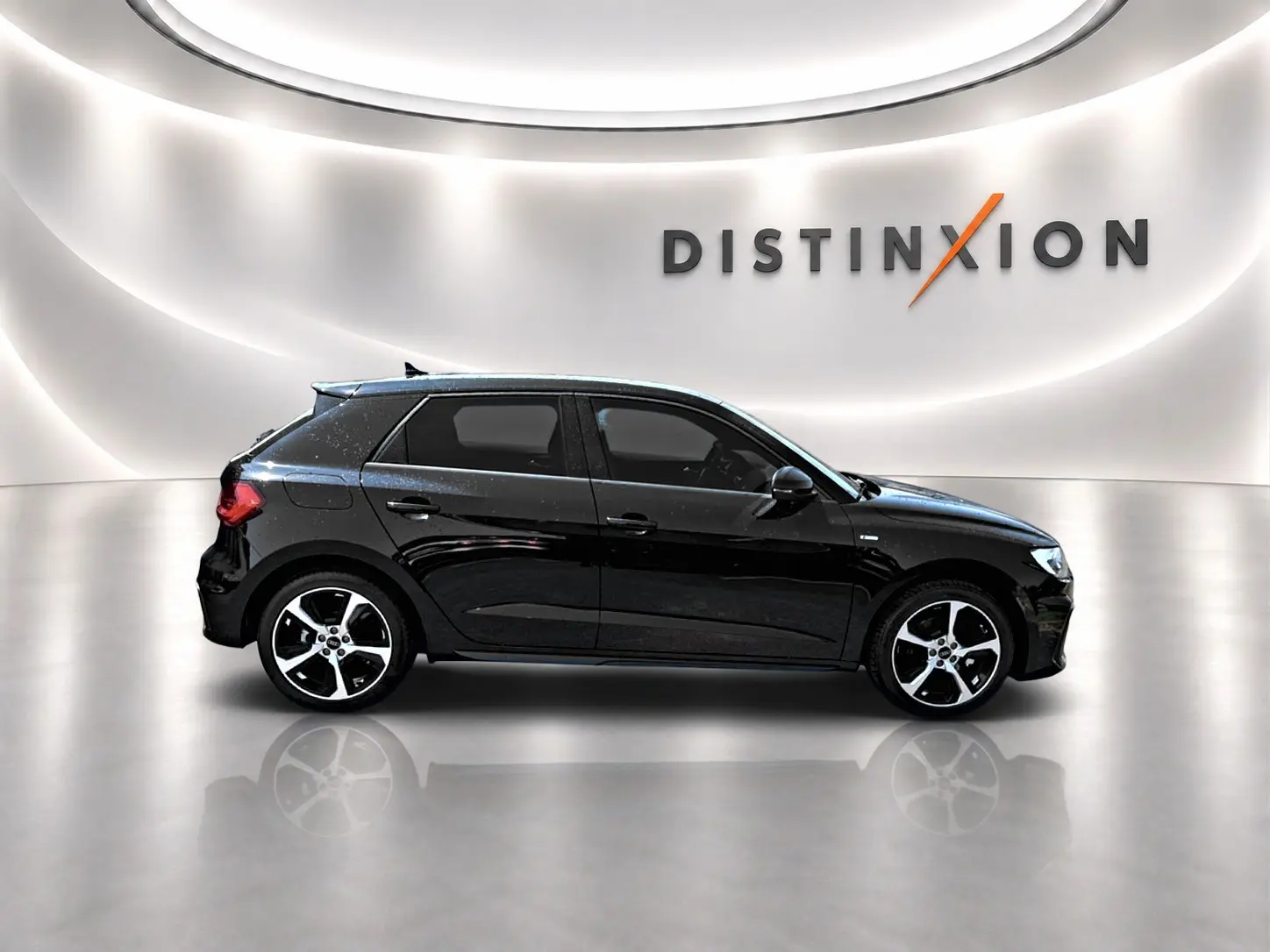 Audi A1 Sportback noir vue de profil côté gauche, avec jantes alu et becquet arrière en studio lumineux.