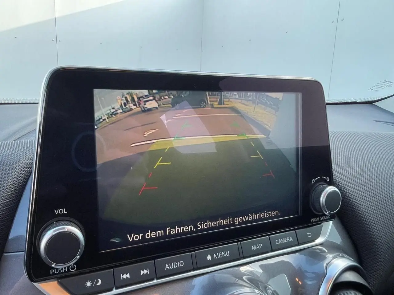 Écran central du Nissan Juke 2024 affichant la caméra de recul avec lignes de guidage colorées.