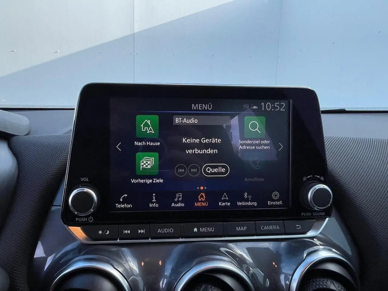 Écran tactile central du Nissan Juke II gris ceramic 2024 avec commandes audio et climatisation visibles