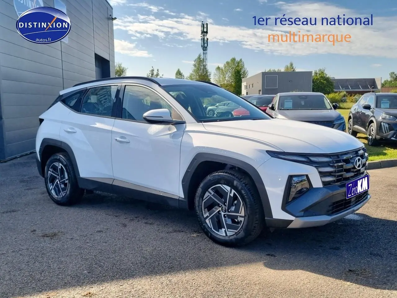 Vue 3/4 avant du Hyundai Tucson blanc atlas avec calandre grise et jantes alliage 17 pouces.