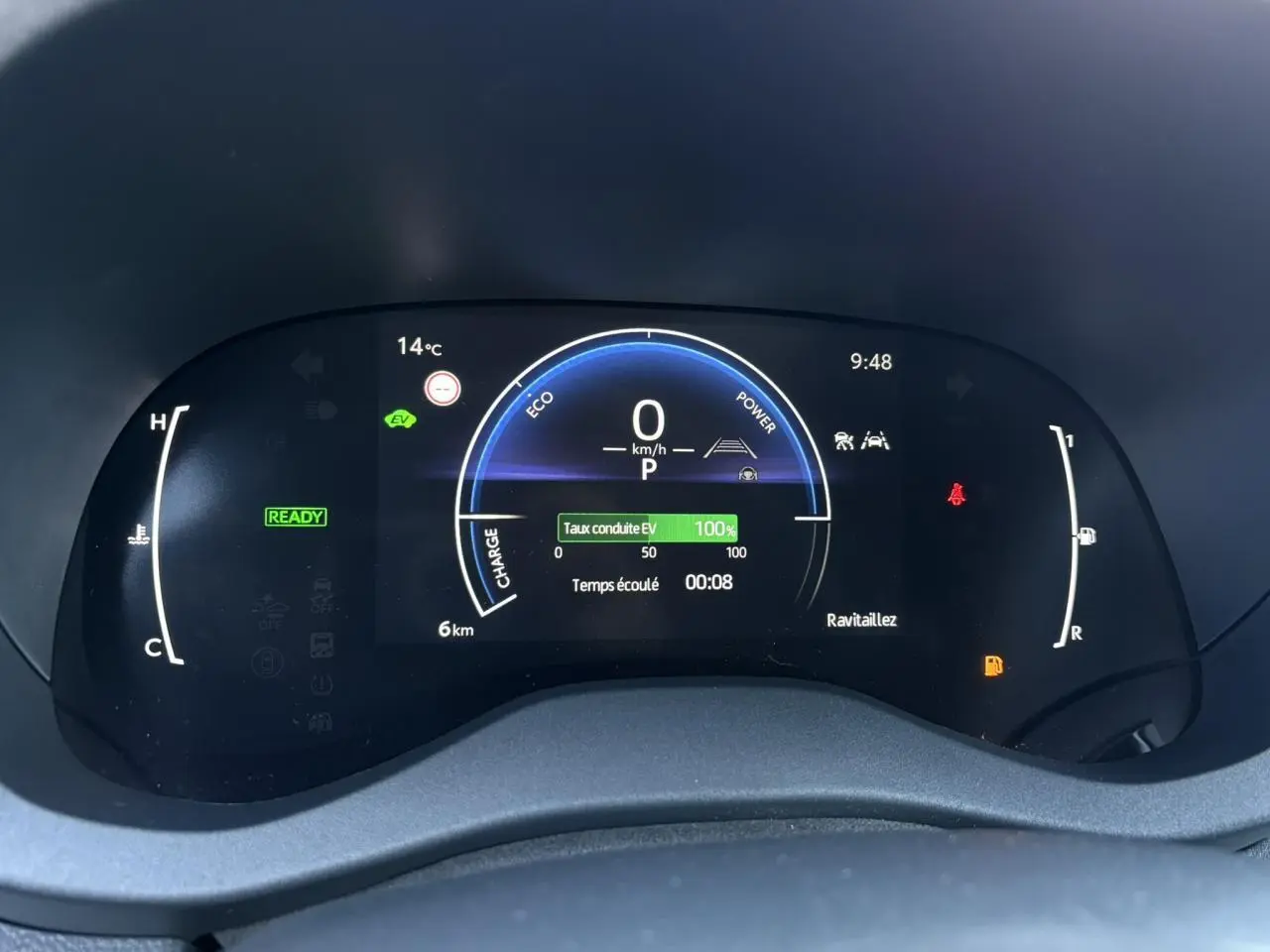 Tableau de bord numérique de la Toyota Yaris Hybride 2025 affichant vitesse, température et indicateurs de conduite électrique.