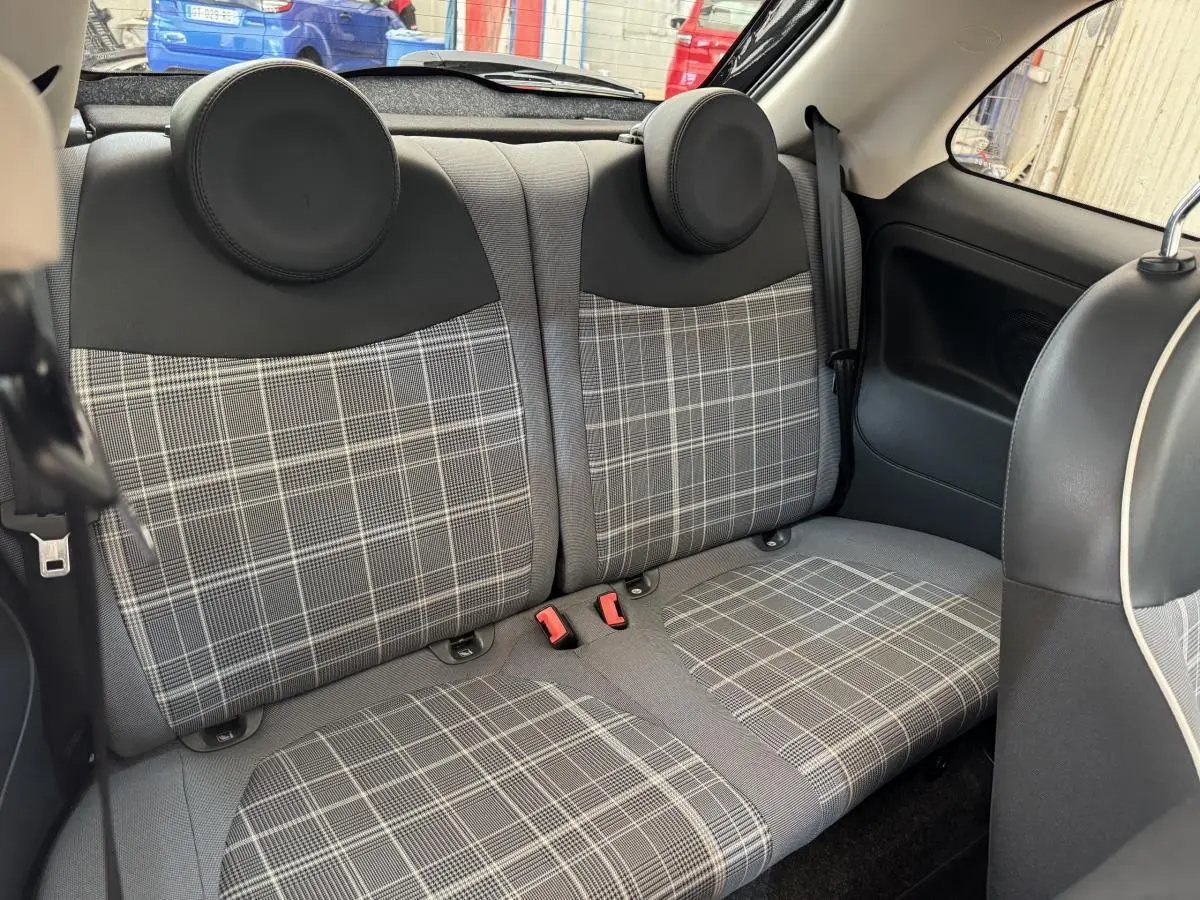 Banquette arrière à motifs carreaux gris et noir dans une Fiat 500 Lounge 2019 vue de l'intérieur côté droit.