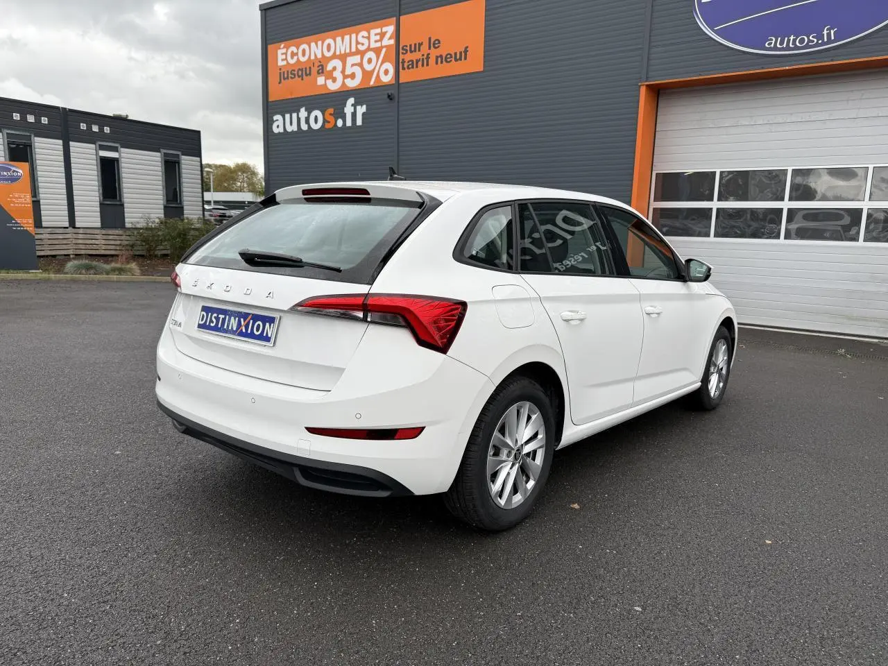 Vue 3/4 arrière droite d'une Skoda Scala blanche 2023 avec jantes alliage et feux arrière LED distinctifs.