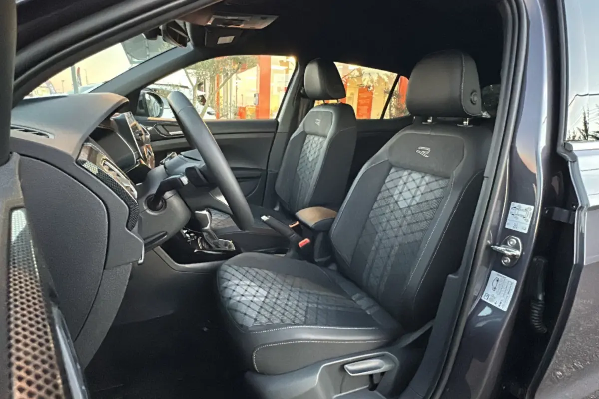 Intérieur du Volkswagen T-Cross gris cendré, vue côté gauche sur les sièges avant R-Line en tissu avec surpiqûres grises.