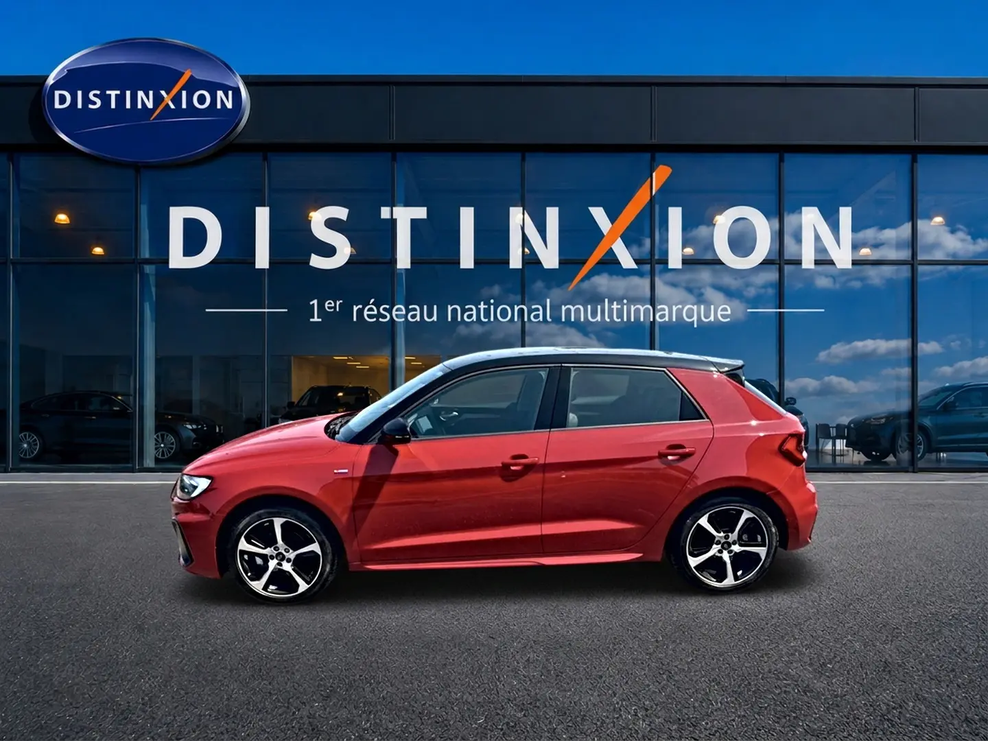 Audi A1 Sportback rouge à toit noir vue de profil côté gauche devant une vitrine Distinxion.