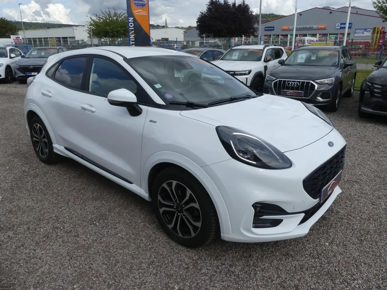 Ford Puma blanc en vue 3/4 avant droit avec jantes alliage et vitres arrière surteintées sur parking.