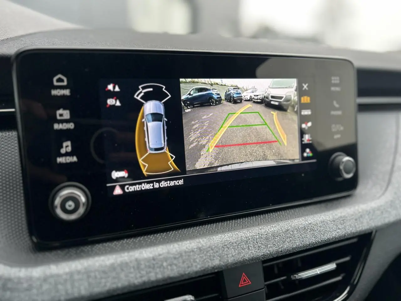Écran tactile intérieur affichant la caméra de recul et l’aide au stationnement du Skoda Kamiq noir Magic.