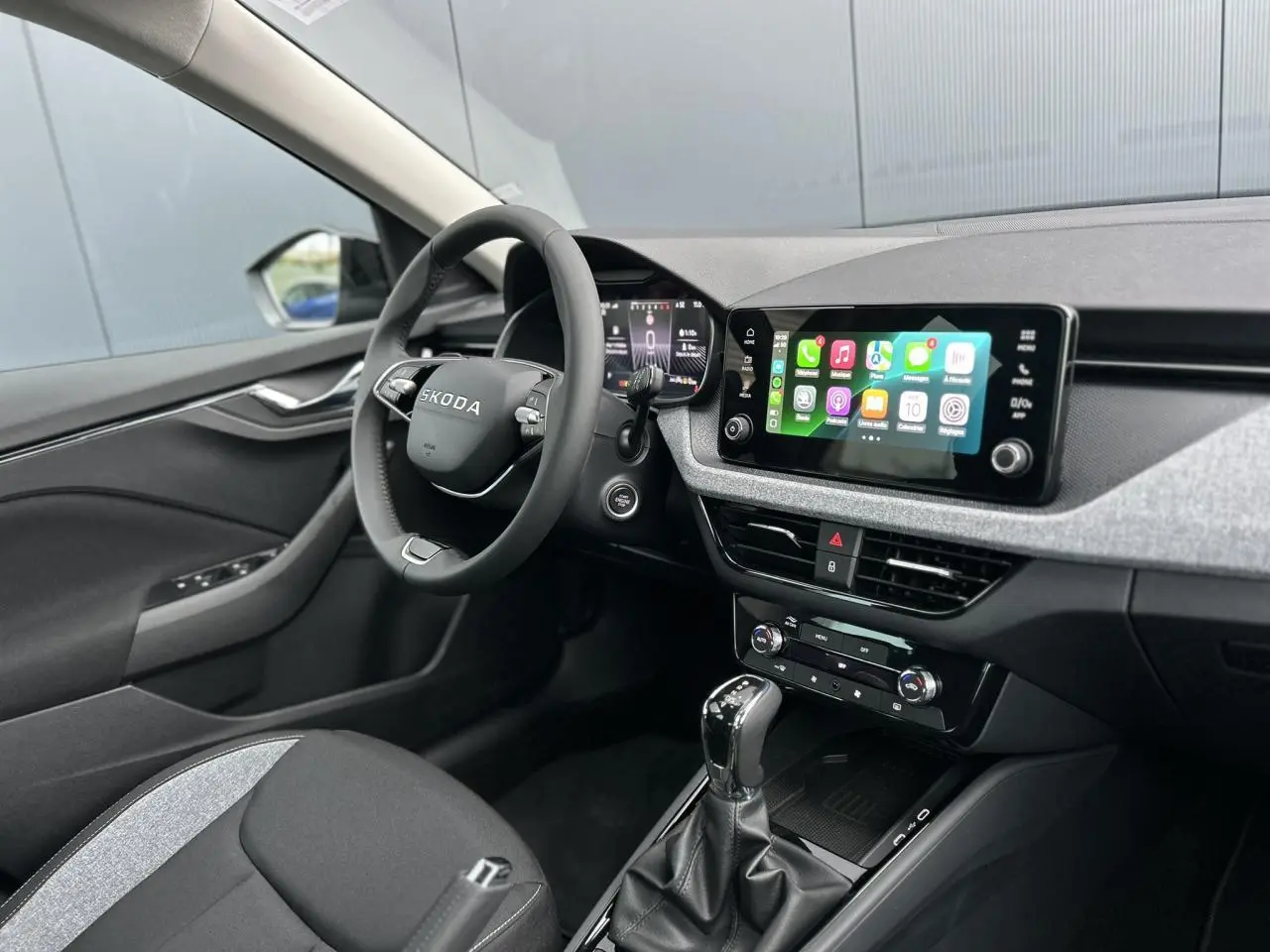 Intérieur SKODA KAMIQ 2025 côté conducteur, volant multifonctions, écran tactile Apple Car Play et tableau de bord numérique.