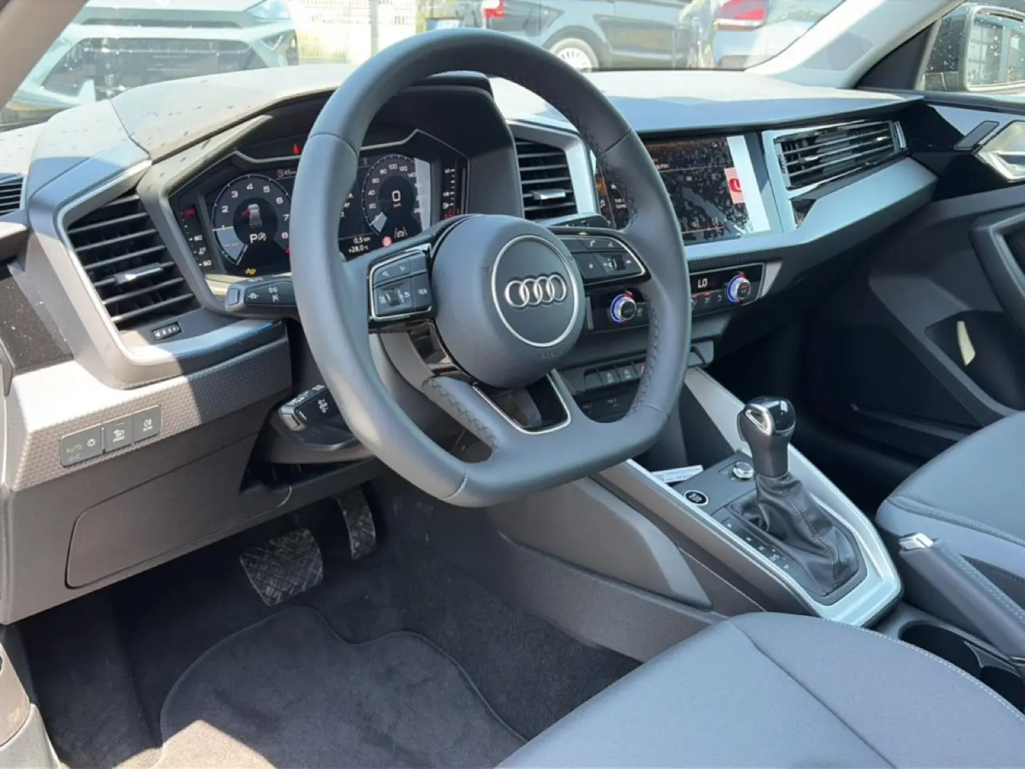 Vue intérieure côté conducteur de l'Audi A1 Sportback 30 TFSI 116 S line 2026, volant cuir multifonction et tableau de bord digital.