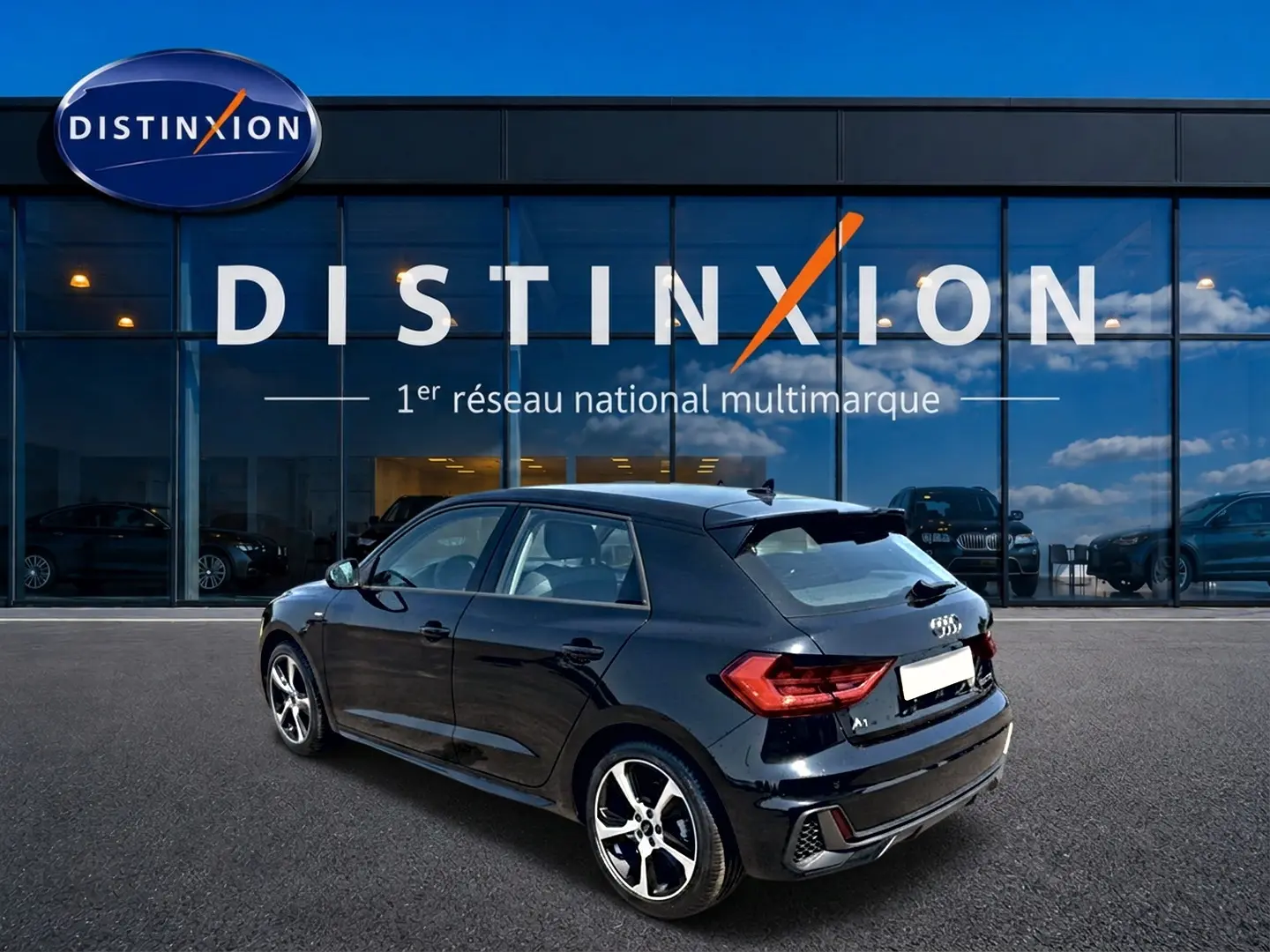 Audi A1 Sportback noir vue 3/4 arrière droit, avec jantes alu et becquet arrière distinctif.