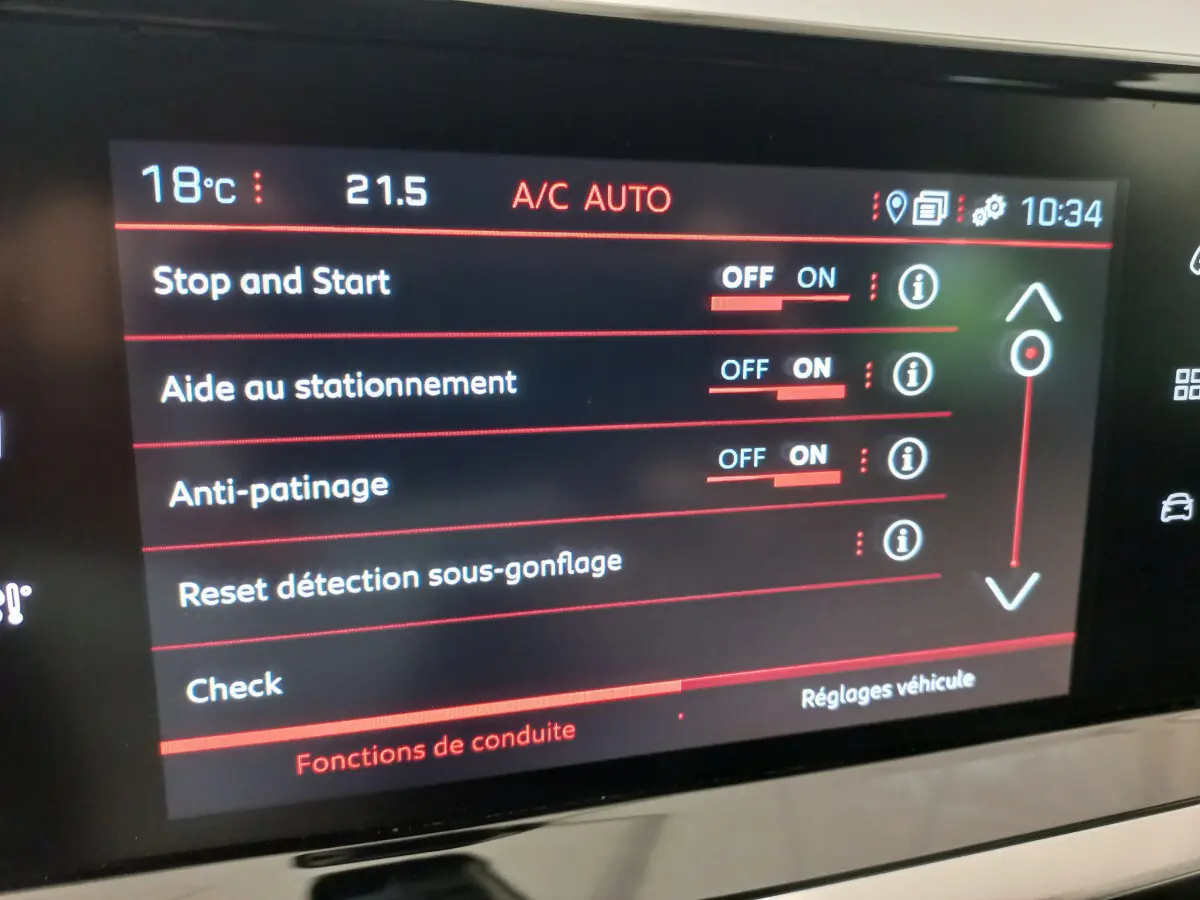 Écran tactile intérieur de la Peugeot 208 blanc, affichant les réglages d'aide à la conduite et climatisation.