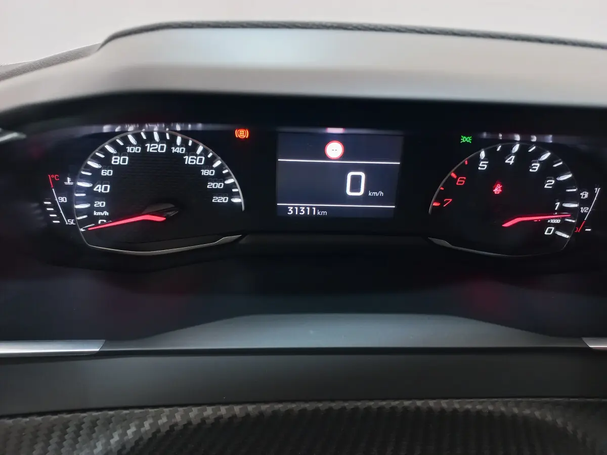 Tableau de bord numérique de Peugeot 208 blanc, affichage vitesse à 0 km/h et compteur kilométrique à 31311 km.