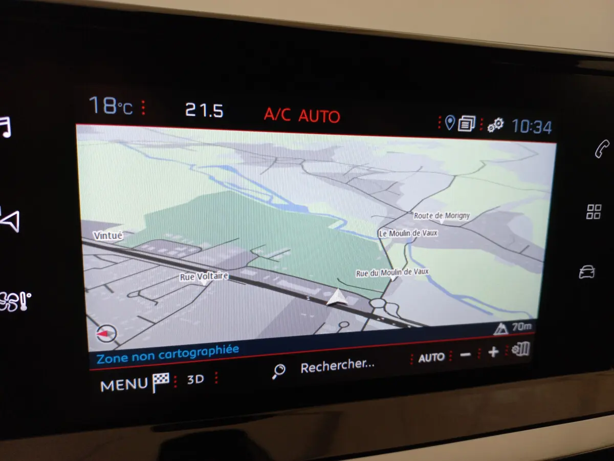 Écran tactile central du tableau de bord de la Peugeot 208 blanche, affichant la navigation GPS en mode 3D.