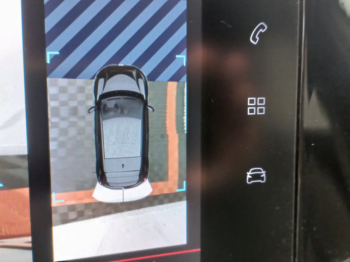 Affichage tactile montrant vue aérienne du véhicule blanc Peugeot 208 PureTech, avec icônes de contrôle sur la droite.