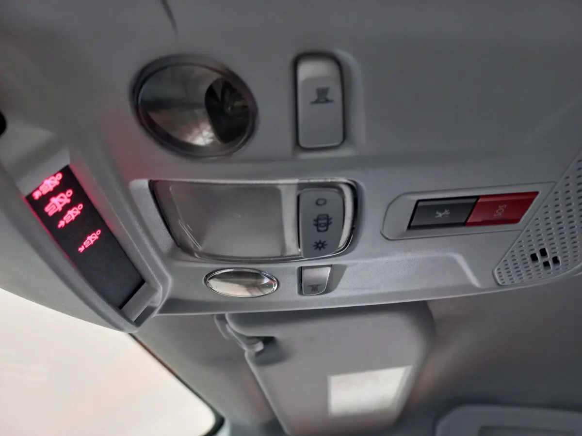 Vue rapprochée du plafonnier gris clair de la Peugeot 208 PureTech 100 S&S Allure avec boutons d'éclairage et SOS rouge.