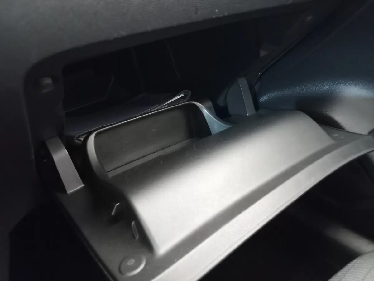 Gros plan sur la boîte à gants ouverte noire à l'intérieur de la Peugeot 208 PureTech 100 S&S Allure 2021.