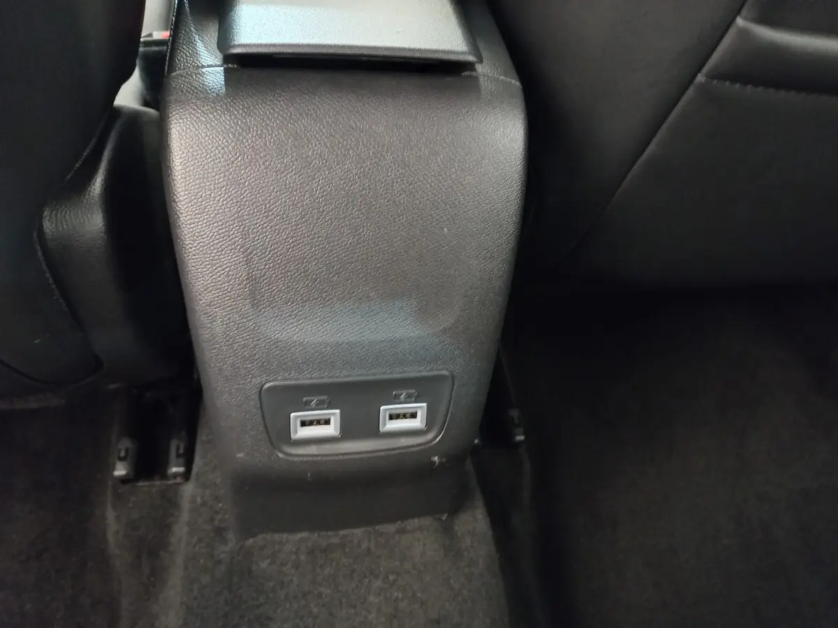 Prise double USB arrière sur console centrale noire dans l'habitacle d'une Peugeot 208 blanche PureTech 2021