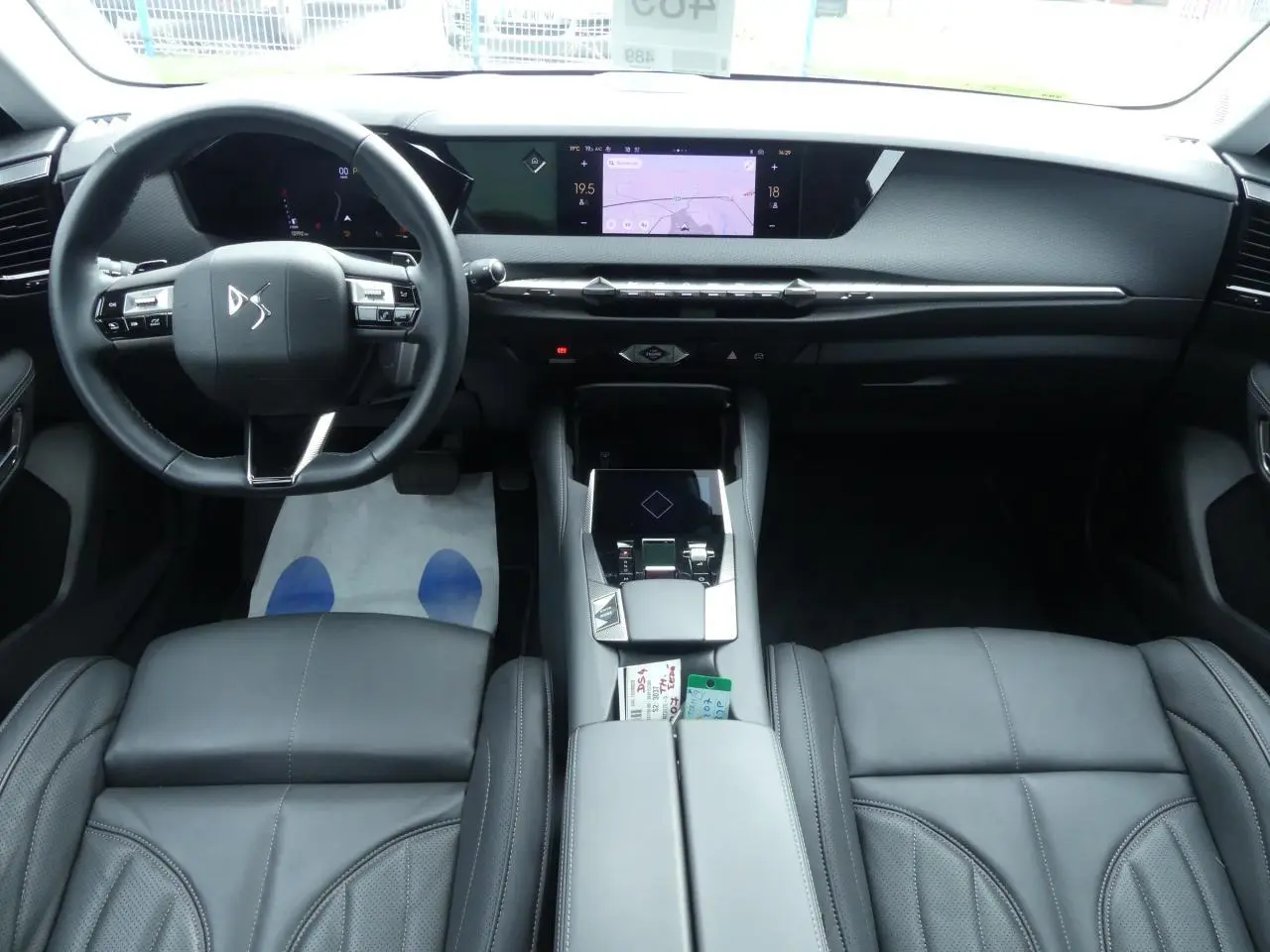 Intérieur noir cuir du DS4 2024 vu de face, avec tableau de bord moderne et écran tactile central lumineux.