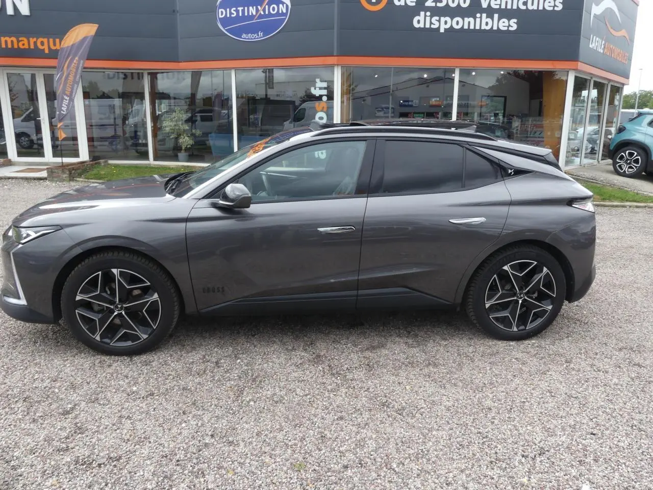 Profil côté gauche d'une DS4 Cross Rivoli gris métallisé avec jantes alliage 19 pouces et vitres teintées.