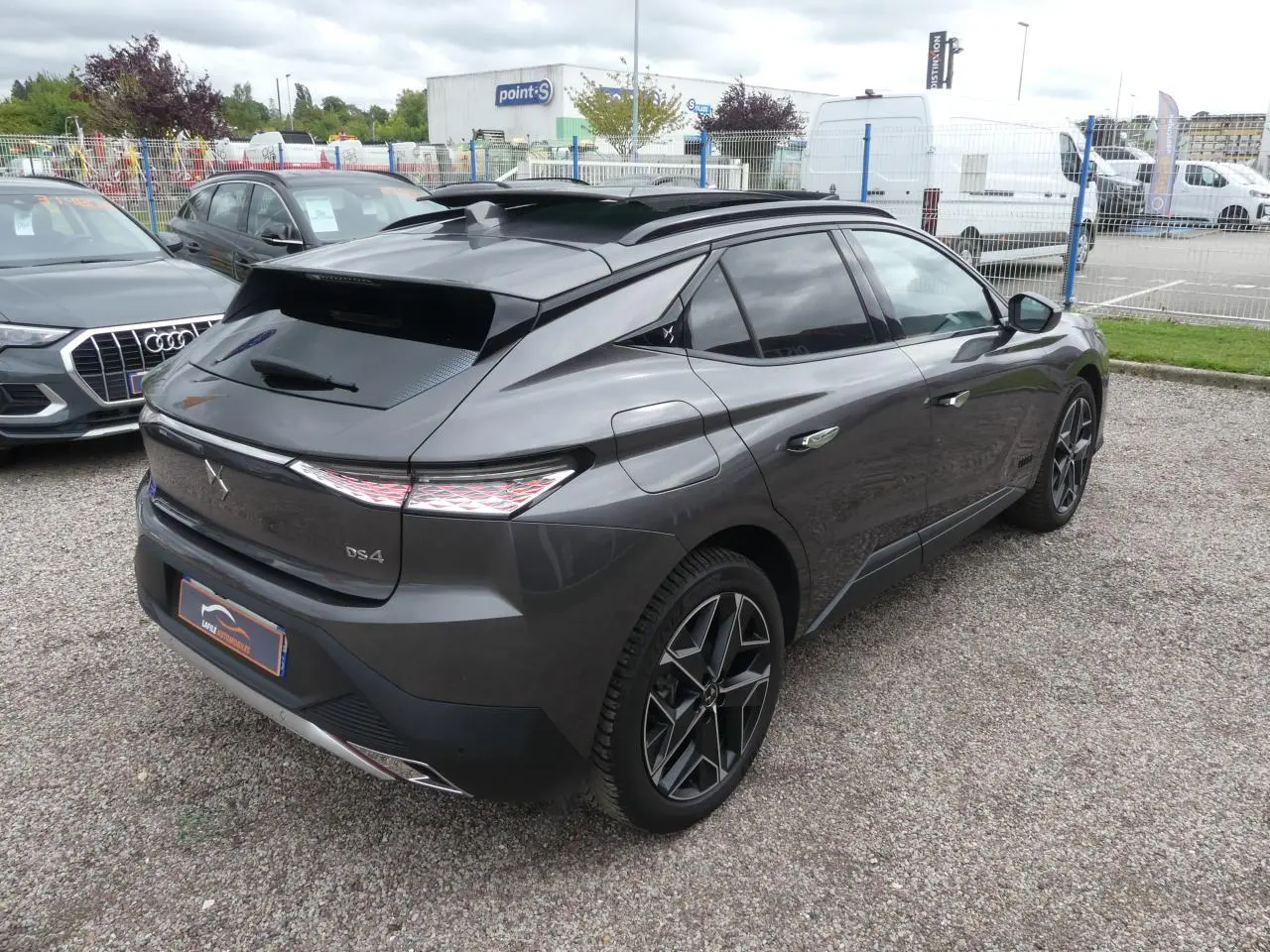 DS4 gris métallisé vu en 3/4 arrière droit, avec feux arrière à effet 3D et jantes alliage noires.