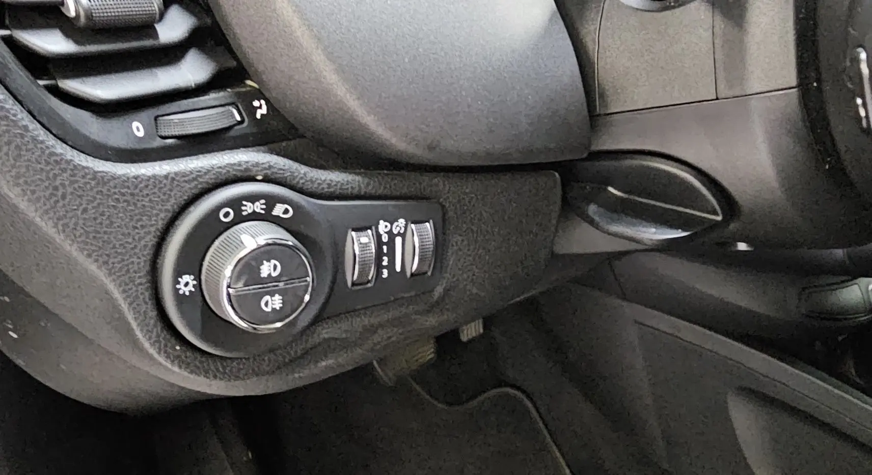 Détail du tableau de bord côté gauche du FIAT 500X 2024, montrant la commande des phares et réglages lumineux.