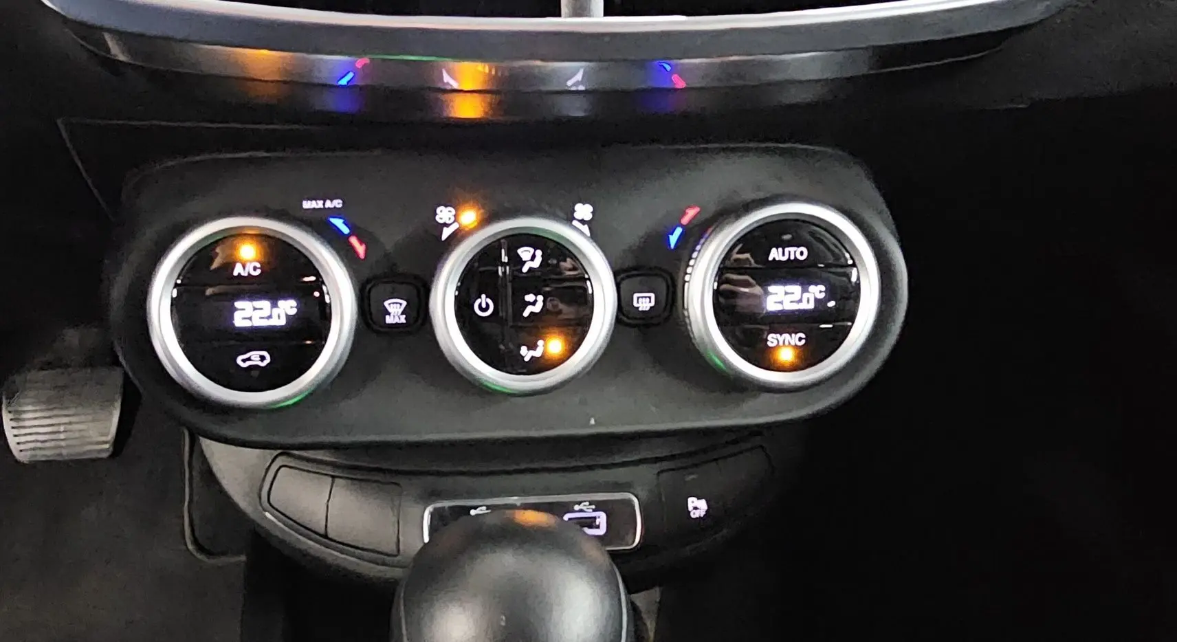 Gros plan sur la console centrale du FIAT 500X bleu 2024, montrant les commandes de climatisation digitales et la boîte automatique.