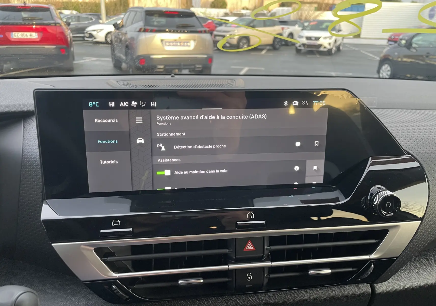 Vue intérieure du tableau de bord de la Citroën C4 hybride 2025, écran tactile affichant les aides à la conduite.