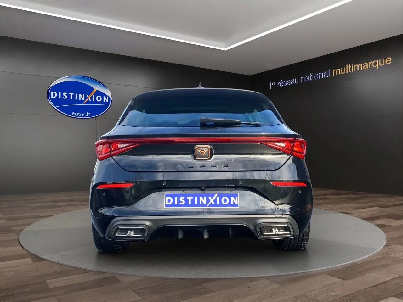 Vue arrière d'une CUPRA Leon noire 2023 avec feux LED reliés et double sortie d'échappement rectangulaire intégrée.