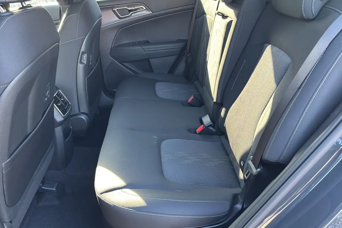Vue intérieure côté droit sur la banquette arrière noire en tissu du Kia Sportage gris eclipse 2026.