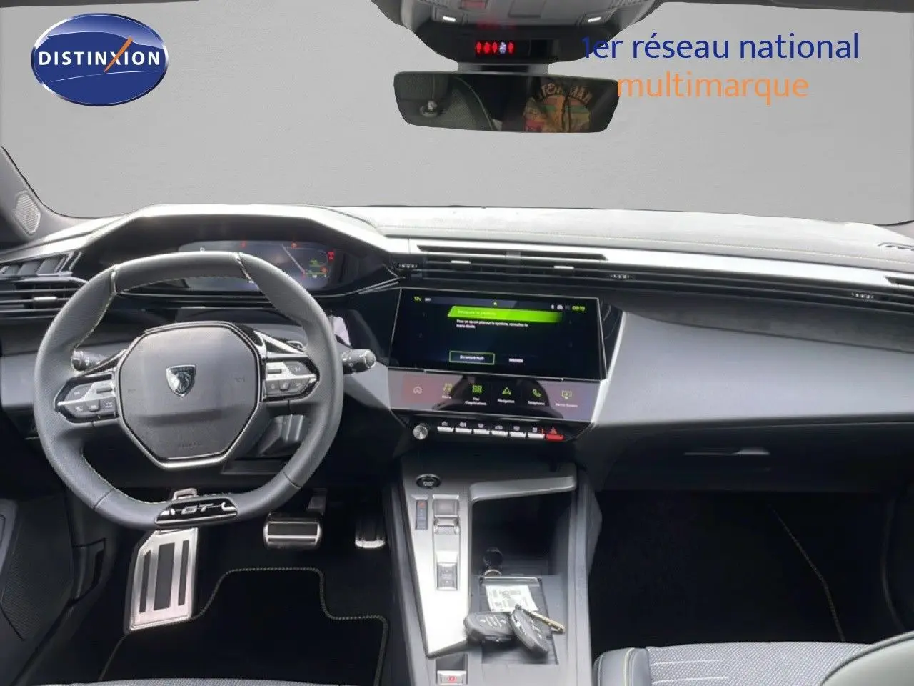 Vue intérieure du tableau de bord et volant cuir noir de la Peugeot 308 gris selenium metal, avec écran tactile central allumé.