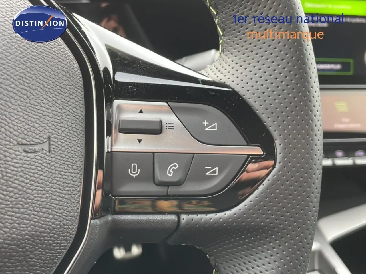 Détail du volant perforé avec commandes intégrées sur la gauche du Peugeot 308 gris Selenium Hybrid 2026.