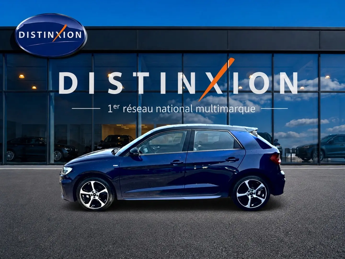 Audi A1 Sportback 30 TFSI S line bleu foncé vue de profil côté gauche devant une vitrine Distinxion.