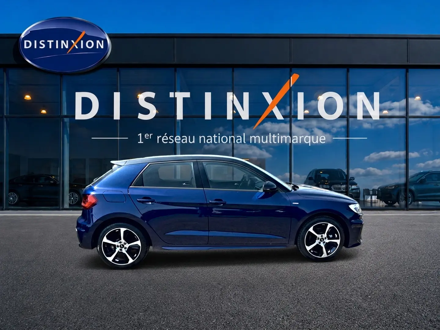 Audi A1 Sportback 30 TFSI S line bleu foncé vue de profil côté gauche devant une vitrine Distinxion.