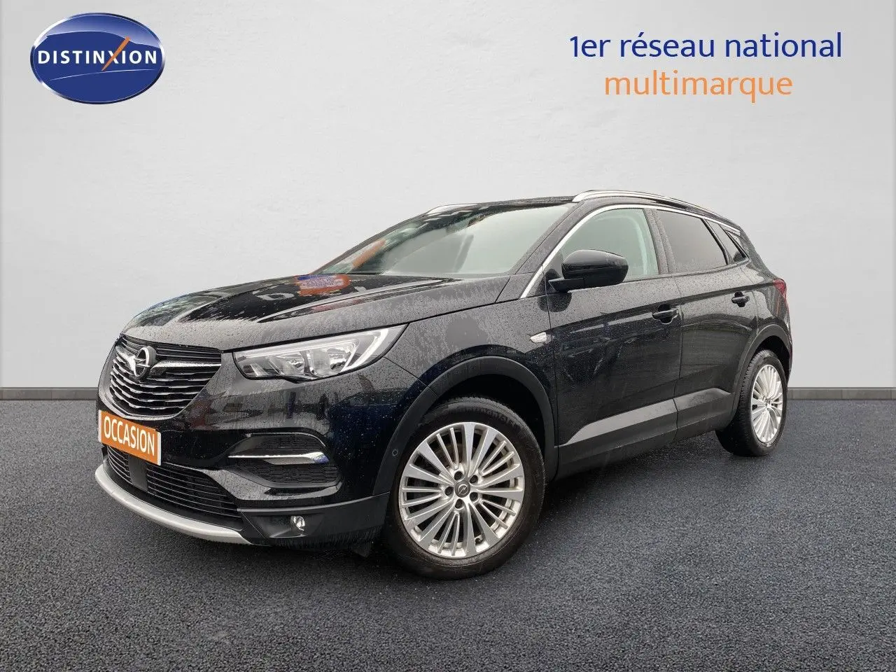 Opel Grandland X noir en 3/4 avant droit, avec jantes alliage et calandre chromée sous un ciel couvert.