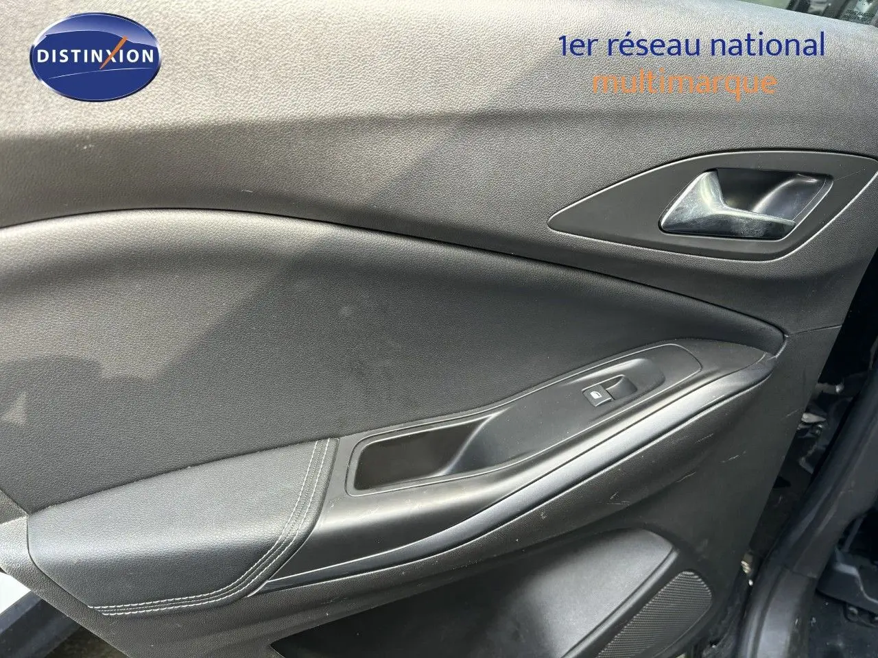 Gros plan sur la porte intérieure côté gauche de l'Opel Grandland X noir, avec poignée et commande de fenêtre visible.