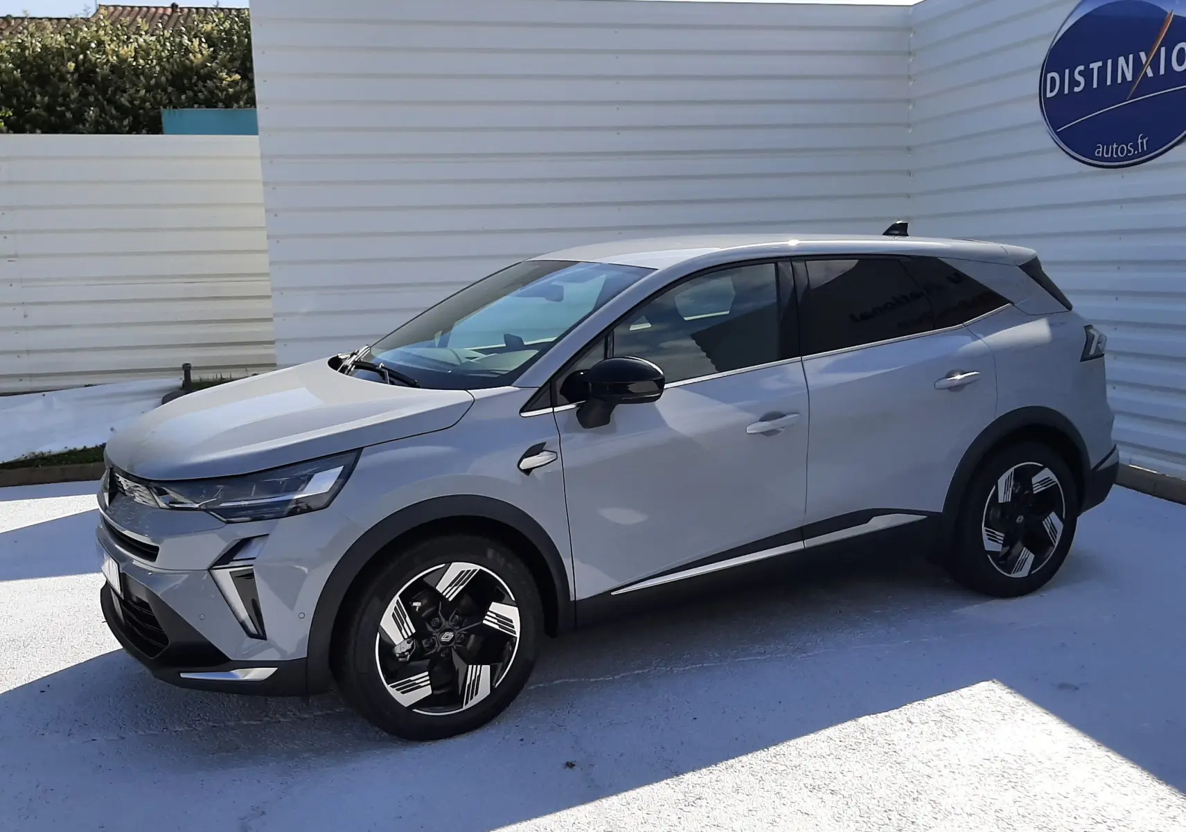 Renault Symbioz gris Rafale en vue 3/4 avant droit, SUV hybride avec jantes noires et détails modernes sur carrosserie.