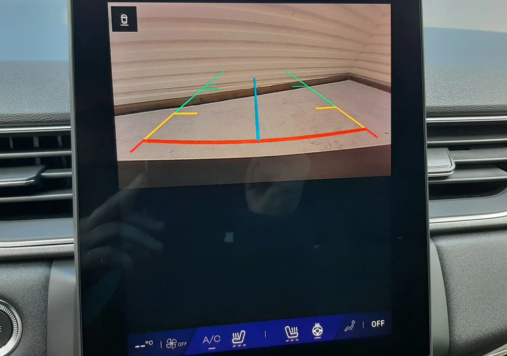 Écran central du Renault Symbioz 2024 affichant la caméra de recul avec guidage coloré dans un intérieur gris.