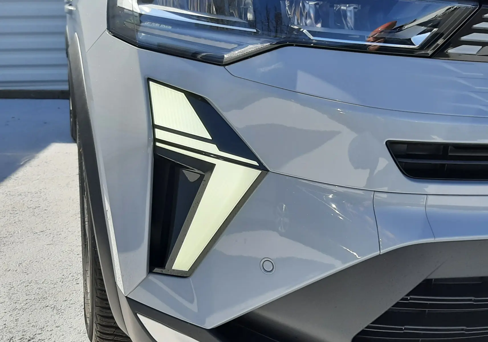 Gros plan sur le phare avant gauche du Renault Symbioz gris Rafale 2024, mettant en valeur son éclairage LED distinctif.