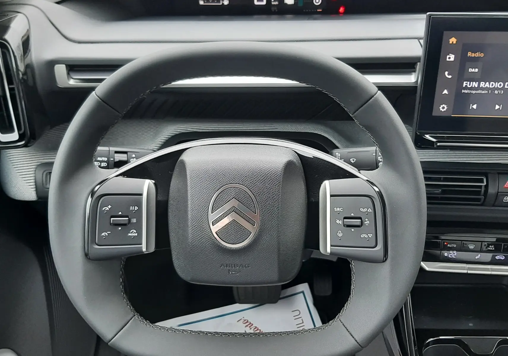 Vue centrée sur le volant de la Citroën C3 Aircross hybride 2025, avec tableau de bord numérique et écran tactile visible.