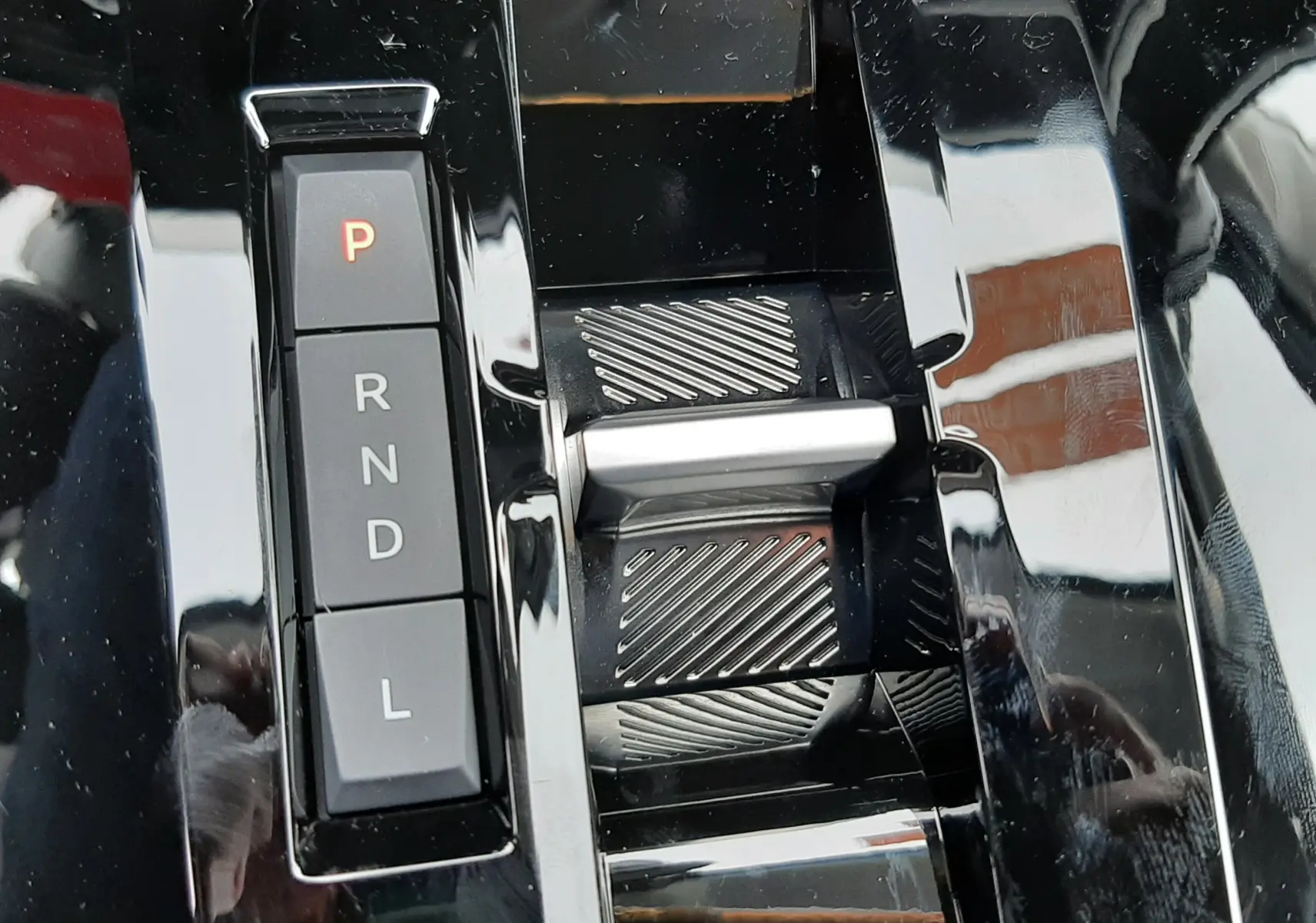 Gros plan sur la commande de boîte automatique noire brillante du Citroën C3 Aircross hybride 2025 avec sélecteur électronique.