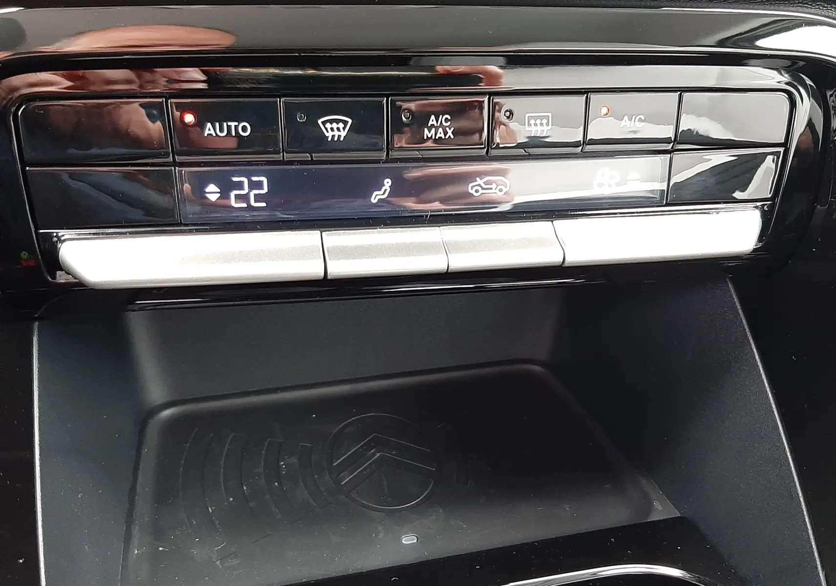 Panneau de commande de climatisation tactile avec affichage digital et zone de recharge sans fil dans une Citroën C3 Aircross hybride 2025.
