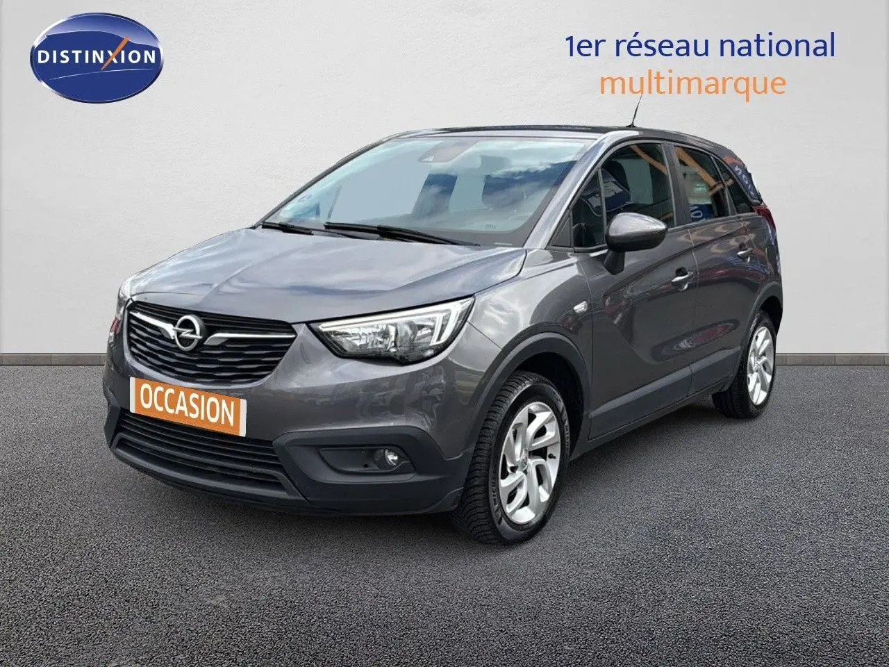 Opel Crossland X gris pierre de lune métal en 3/4 avant droit avec calandre noire et jantes argentées.