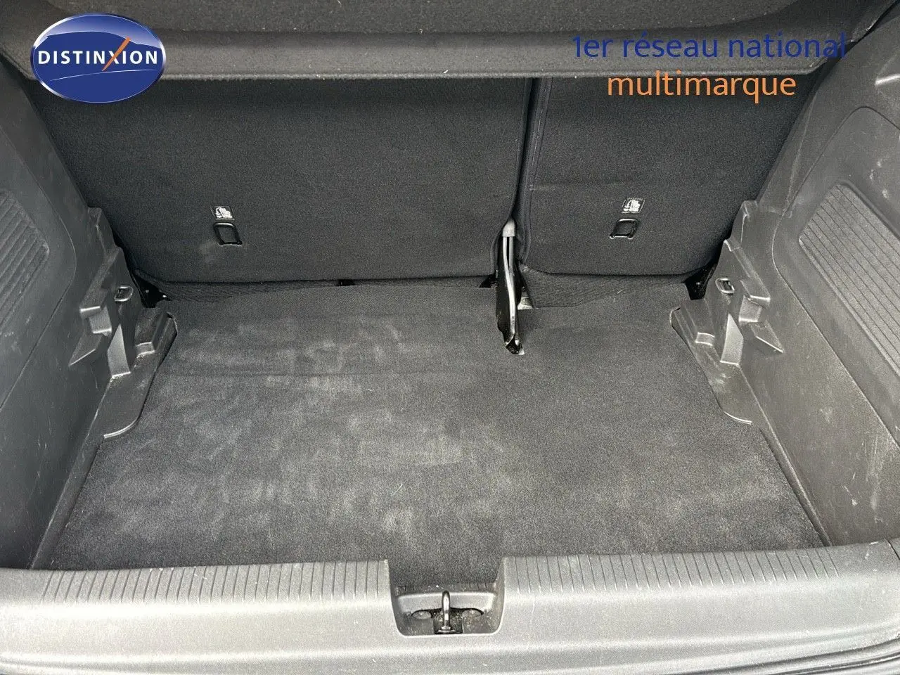 Coffre ouvert d'un Opel Crossland X gris pierre de lune métal, vue plongeante sur l'espace de chargement vide.