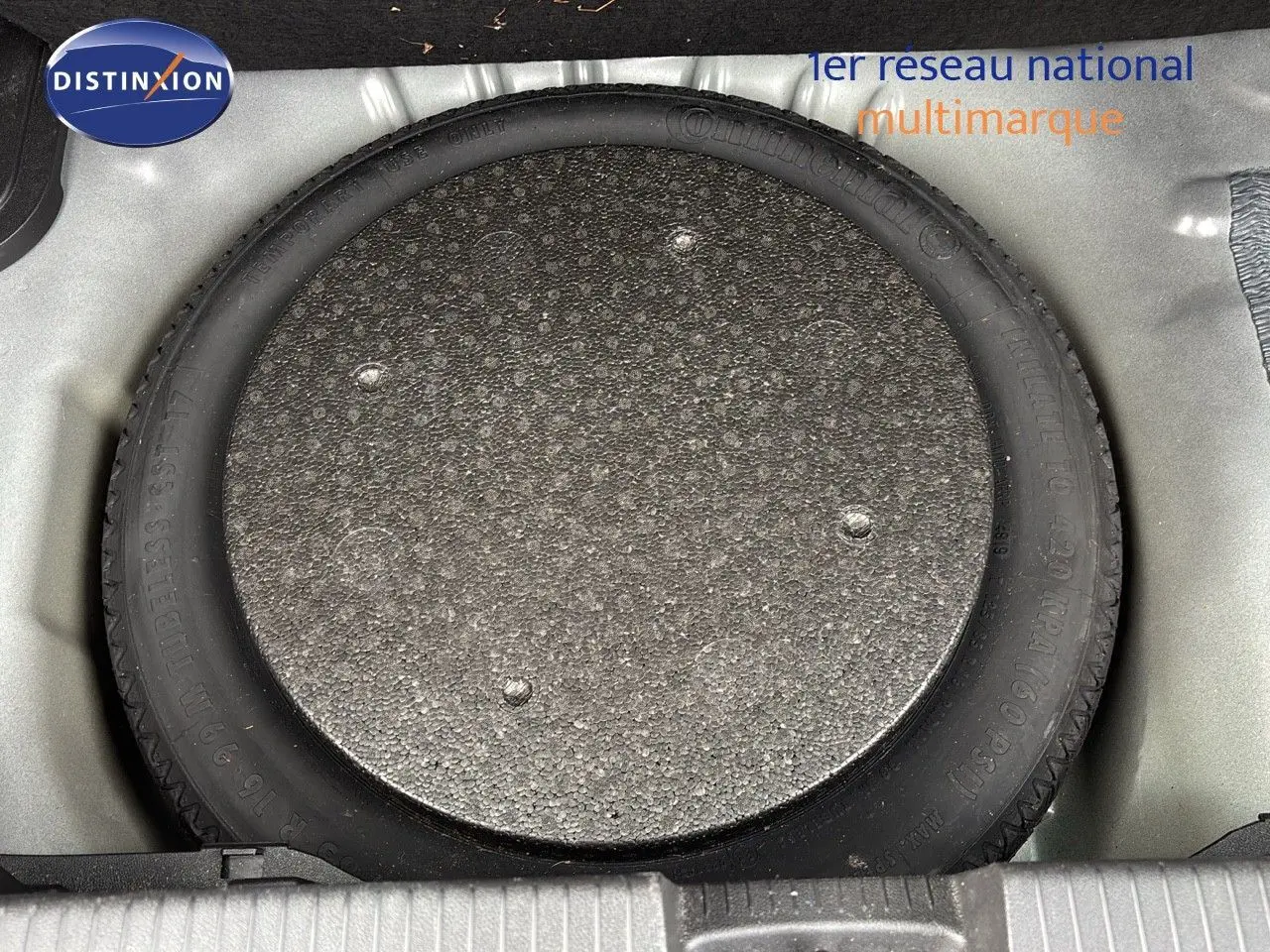 Gros plan sur la roue de secours dans le coffre d'une Opel Crossland X gris Pierre de Lune Métal.