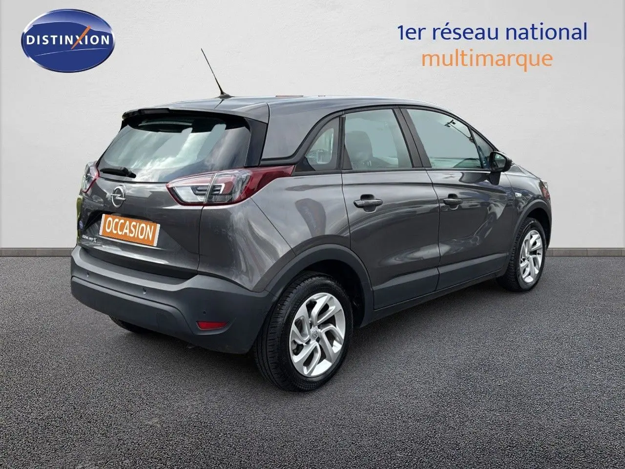 Vue 3/4 arrière droite d'un Opel Crossland X gris Pierre de Lune métallisé avec toit noir et jantes argentées.