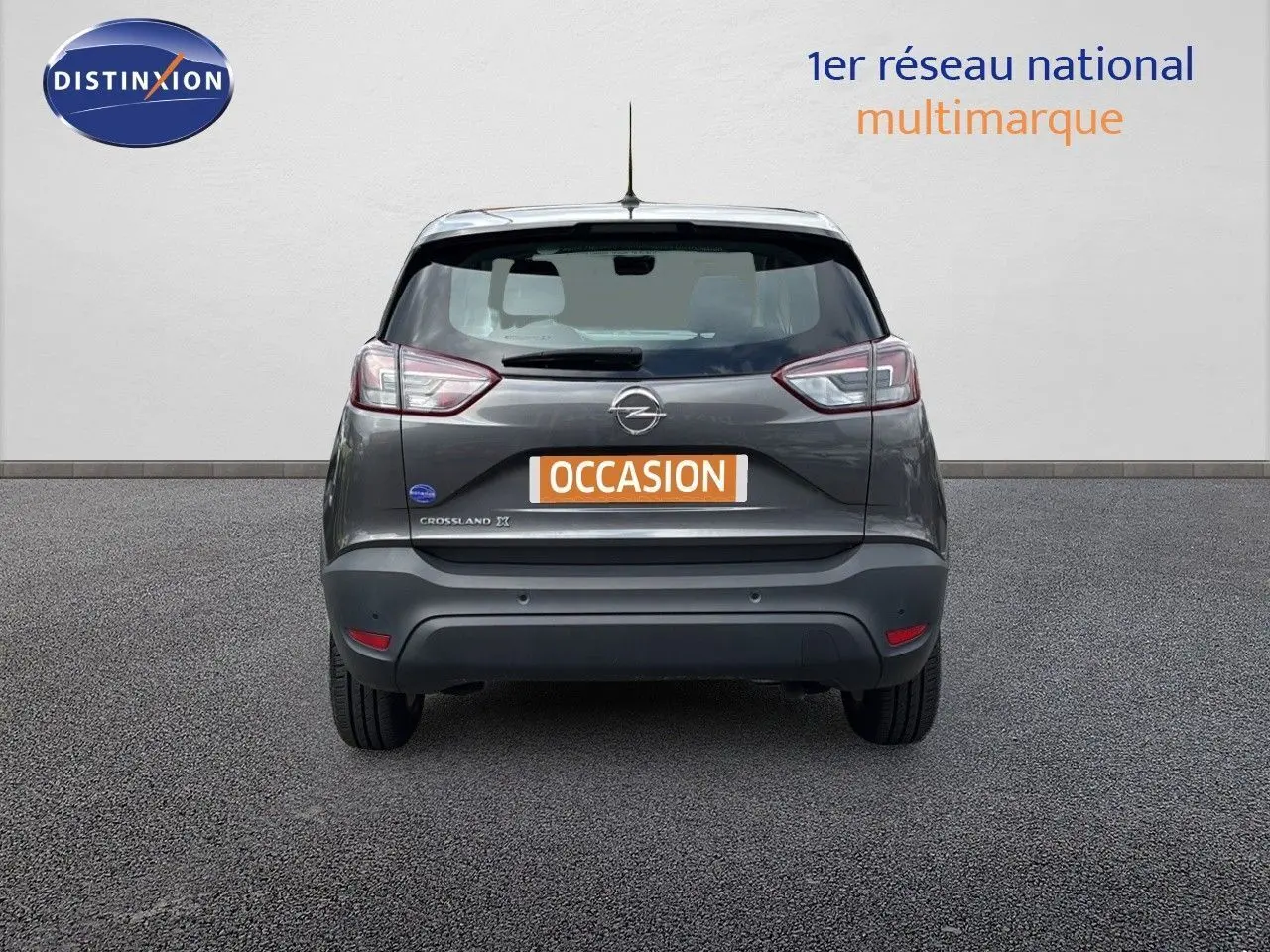 Vue arrière d'un Opel Crossland X gris pierre de lune métal avec logo et plaque d'occasion visible.